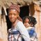 Une maman porte son bébé en écharpe en Afrique.